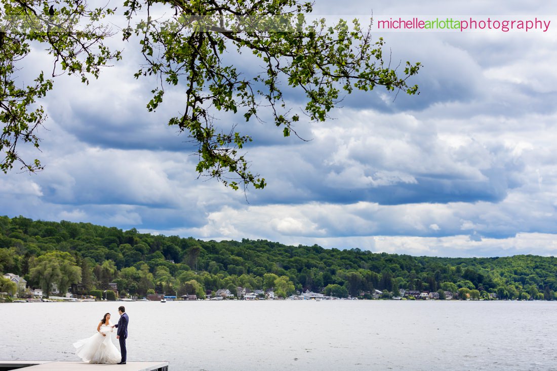 Lake Mohawk Country Club Spring Lakeside NJ wedding with bride and groom on dock with clouds