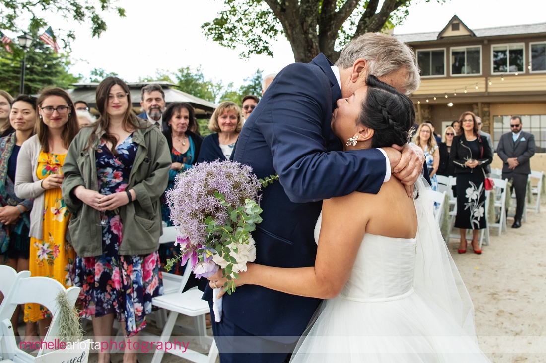 bride hugs father at altar at lake mohawk country club spring lakeside wedding ceremony