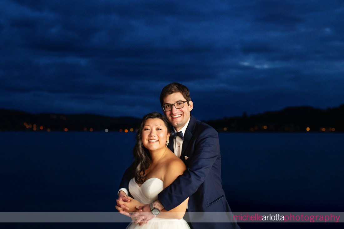 bride and groom nighttime portrait in front of Lake Mohawk in New Jersey