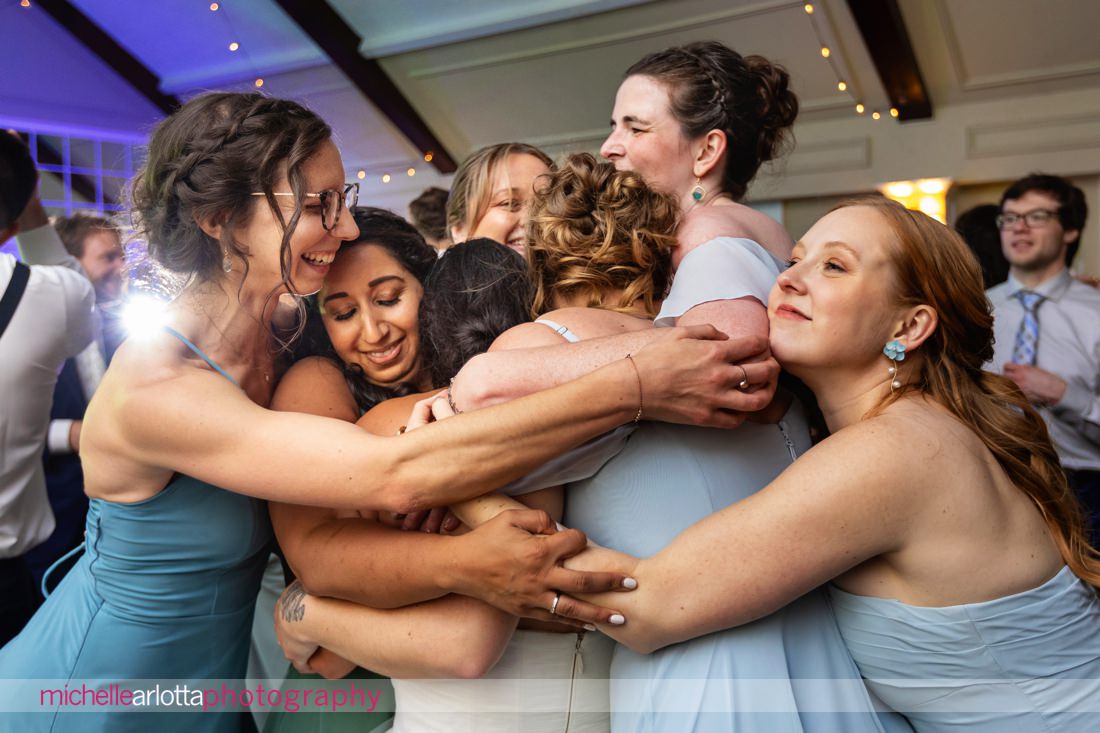 bride and bridesmaids embrace during Lake Mohawk Country Club Spring Lakeside NJ Wedding reception
